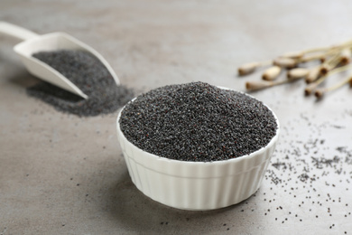 Poppy seeds in bowl on grey table