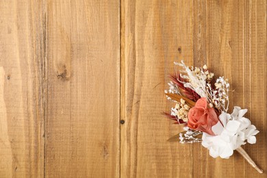 Photo of Stylish boutonniere on wooden table, top view. Space for text