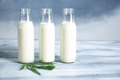 Photo of Glass bottles with hemp milk on table