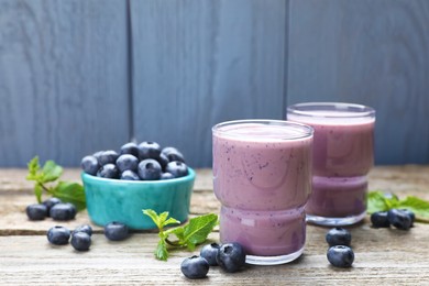 Freshly made blueberry smoothie on wooden table. Space for text