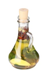 Glass jug of cooking oil with spices and herbs isolated on white