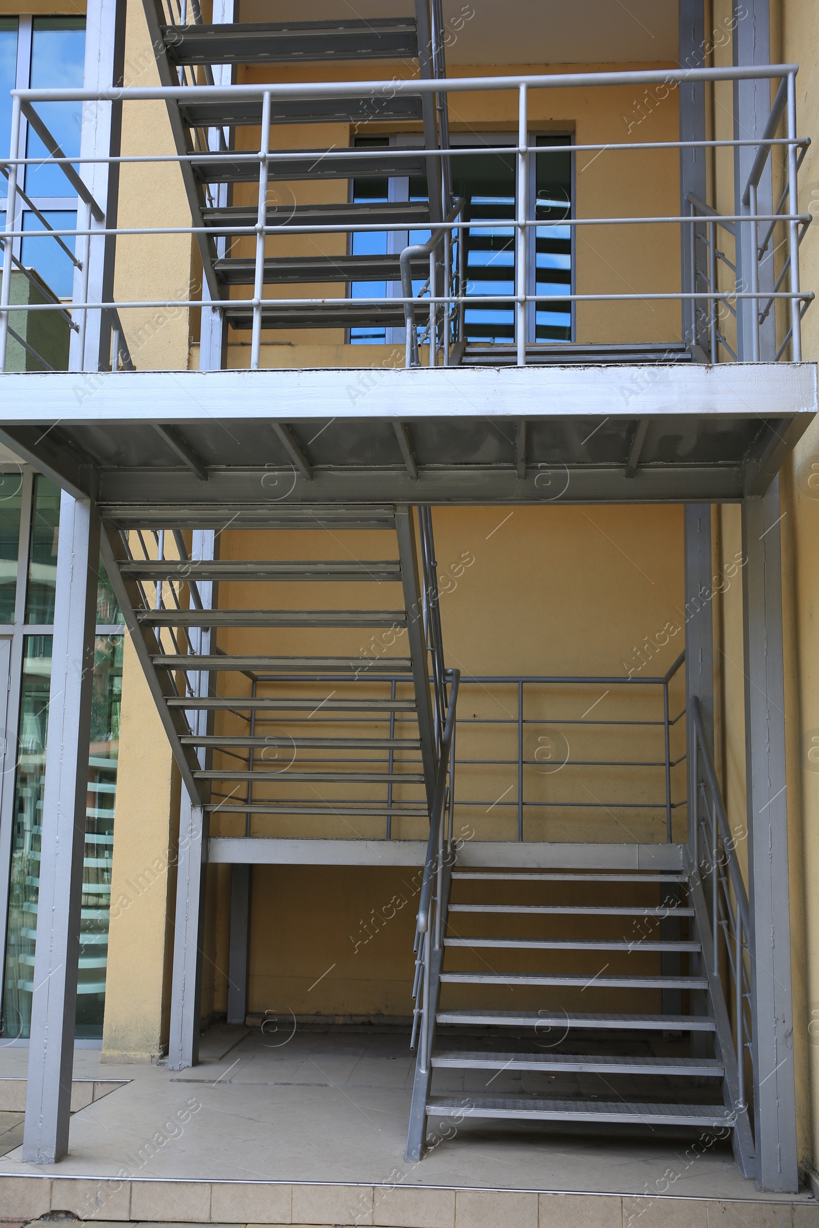 Photo of Metal fire escape ladder near building outdoors, low angle view