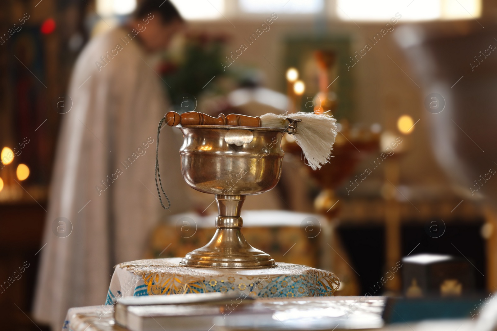 Photo of MYKOLAIV, UKRAINE - FEBRUARY 27, 2021: Vessel with holy water on stand in Kasperovskaya icon of Mother of God cathedral. Baptism ceremony