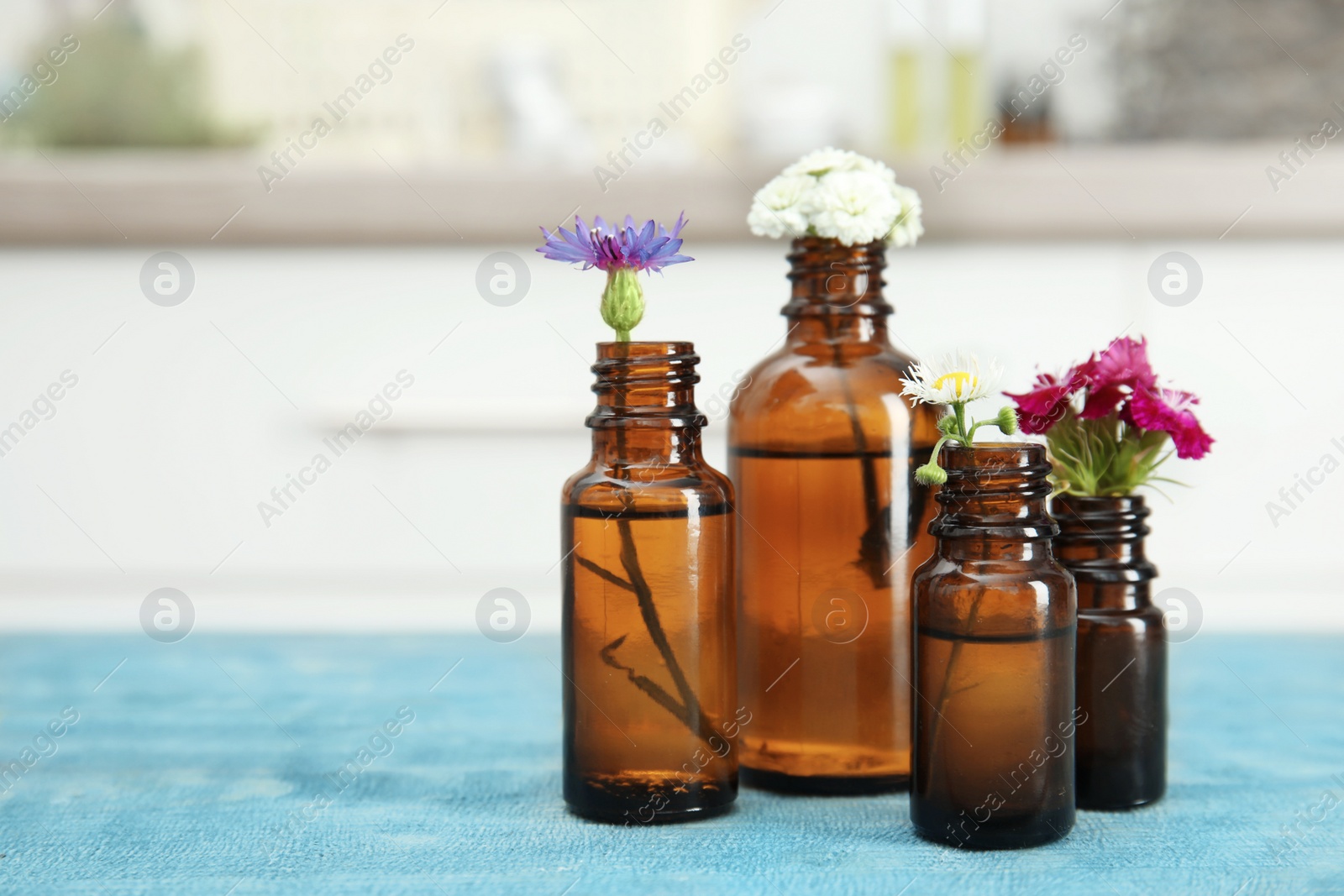 Photo of Composition with essential oils and flowers on table