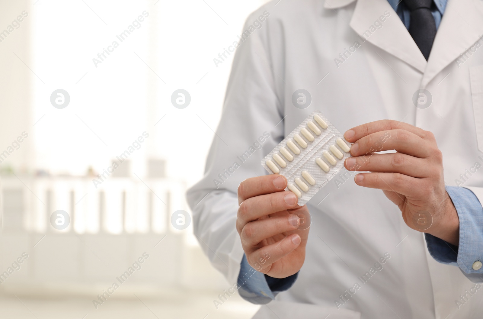 Photo of Professional pharmacist with pills in drugstore, closeup. Space for text