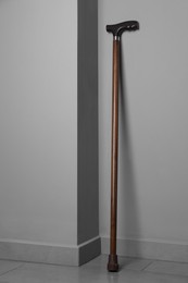 Photo of Elegant walking cane near light grey wall indoors