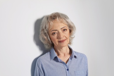Portrait of mature woman on grey background