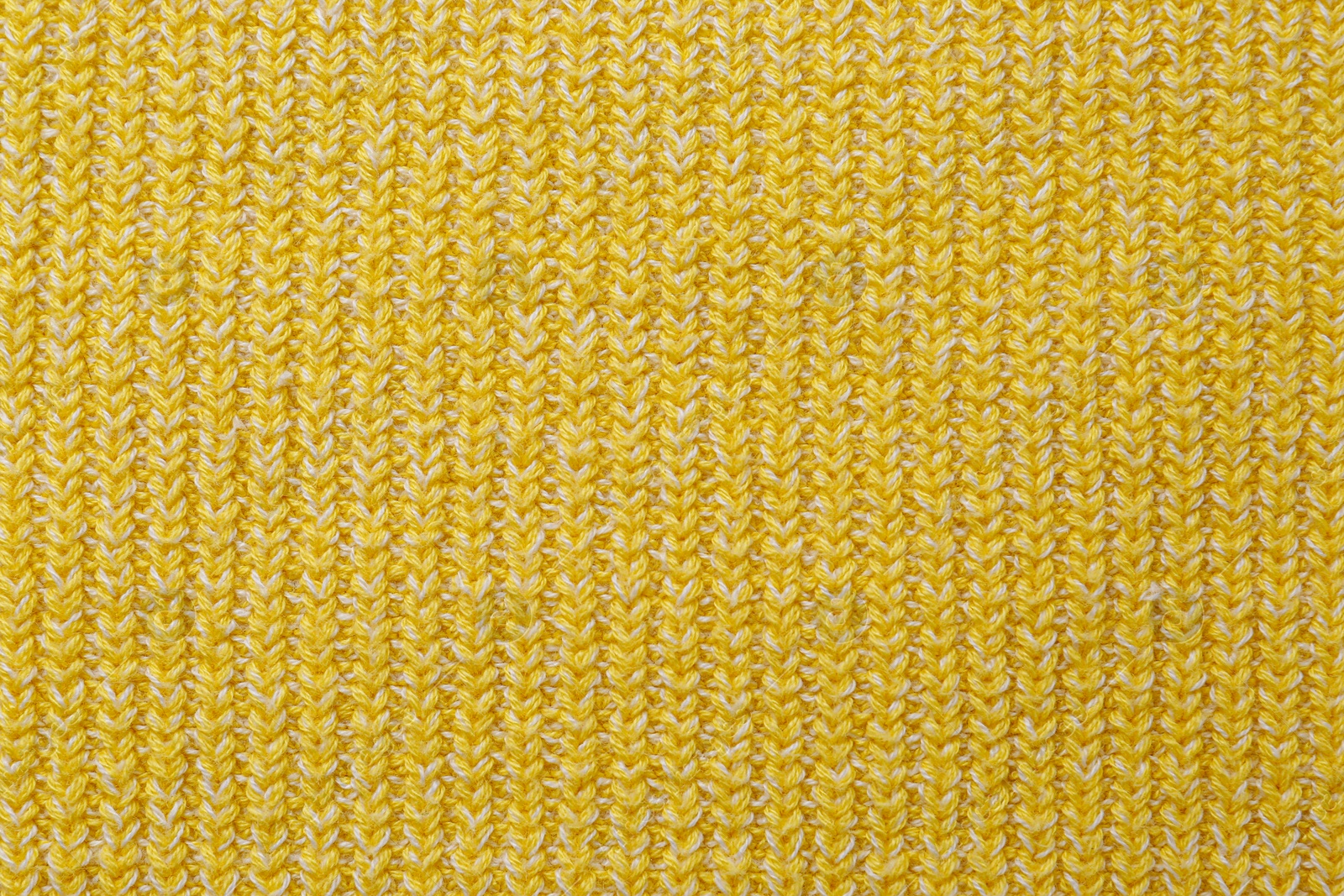 Photo of Yellow knitted fabric as background, top view