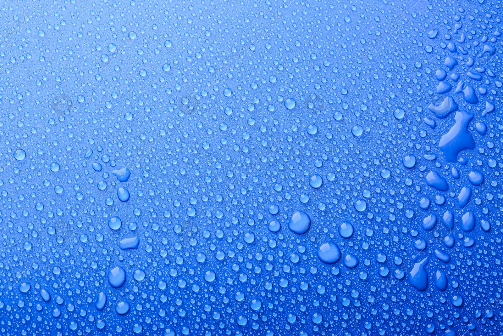 Photo of Water drops on blue background, top view