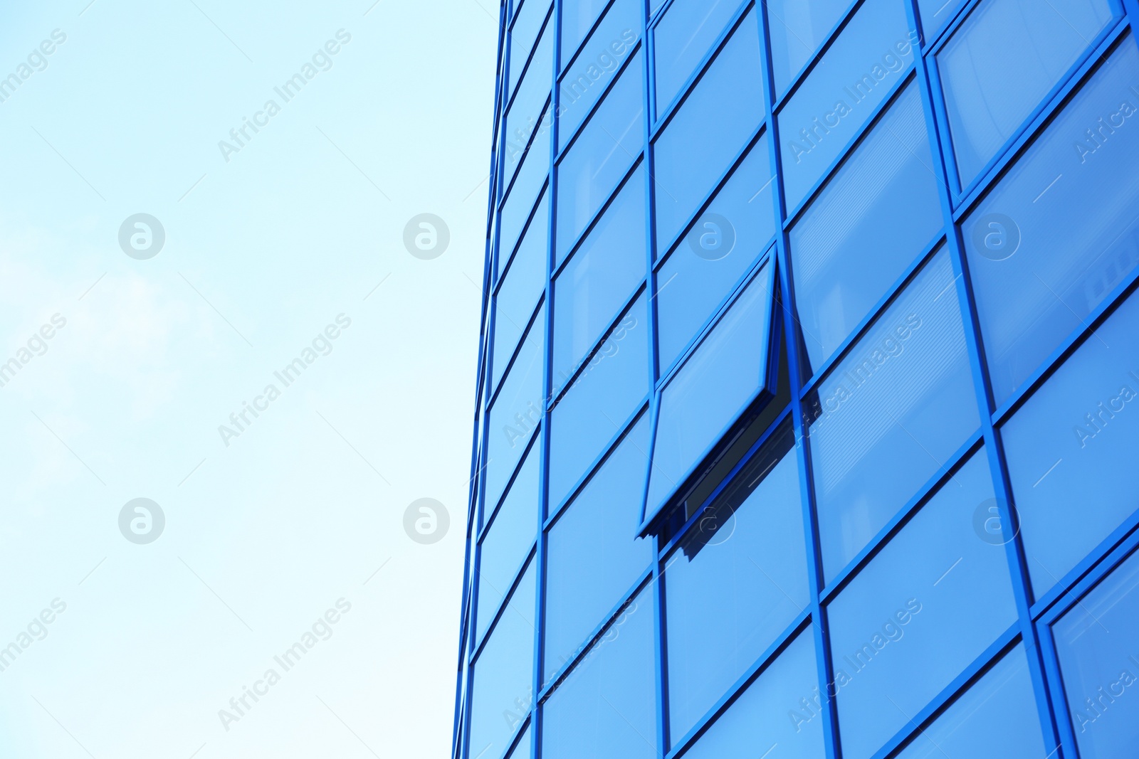 Photo of Modern office building with tinted windows against blue sky