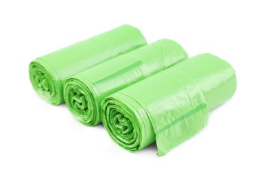 Photo of Rolls of light green garbage bags isolated on white