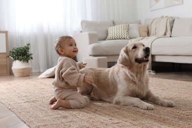 Photo of Cute little baby with adorable dog on floor at home