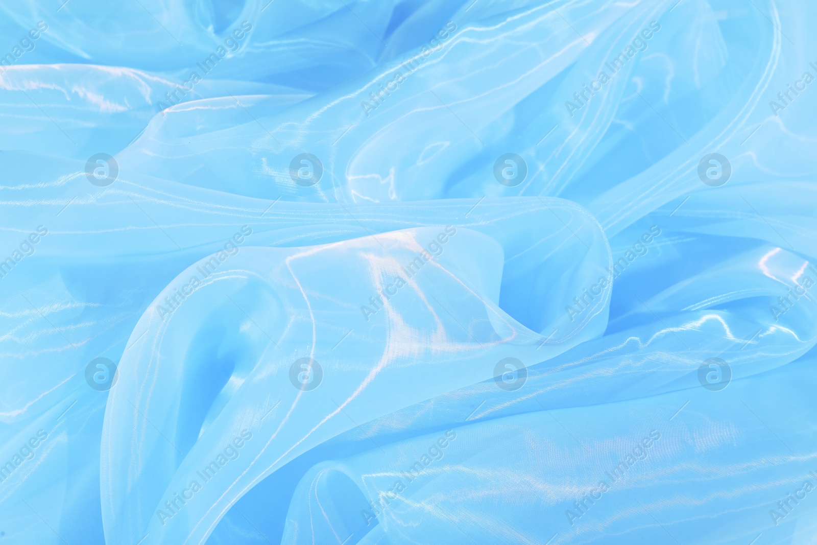 Photo of Beautiful light blue tulle fabric as background, closeup