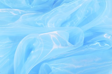 Beautiful light blue tulle fabric as background, closeup
