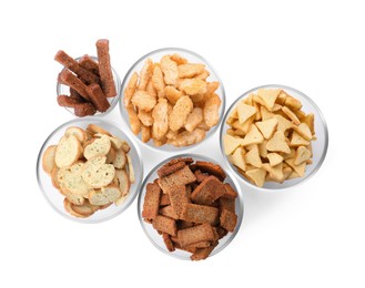 Different crispy rusks in bowls on white background, top view