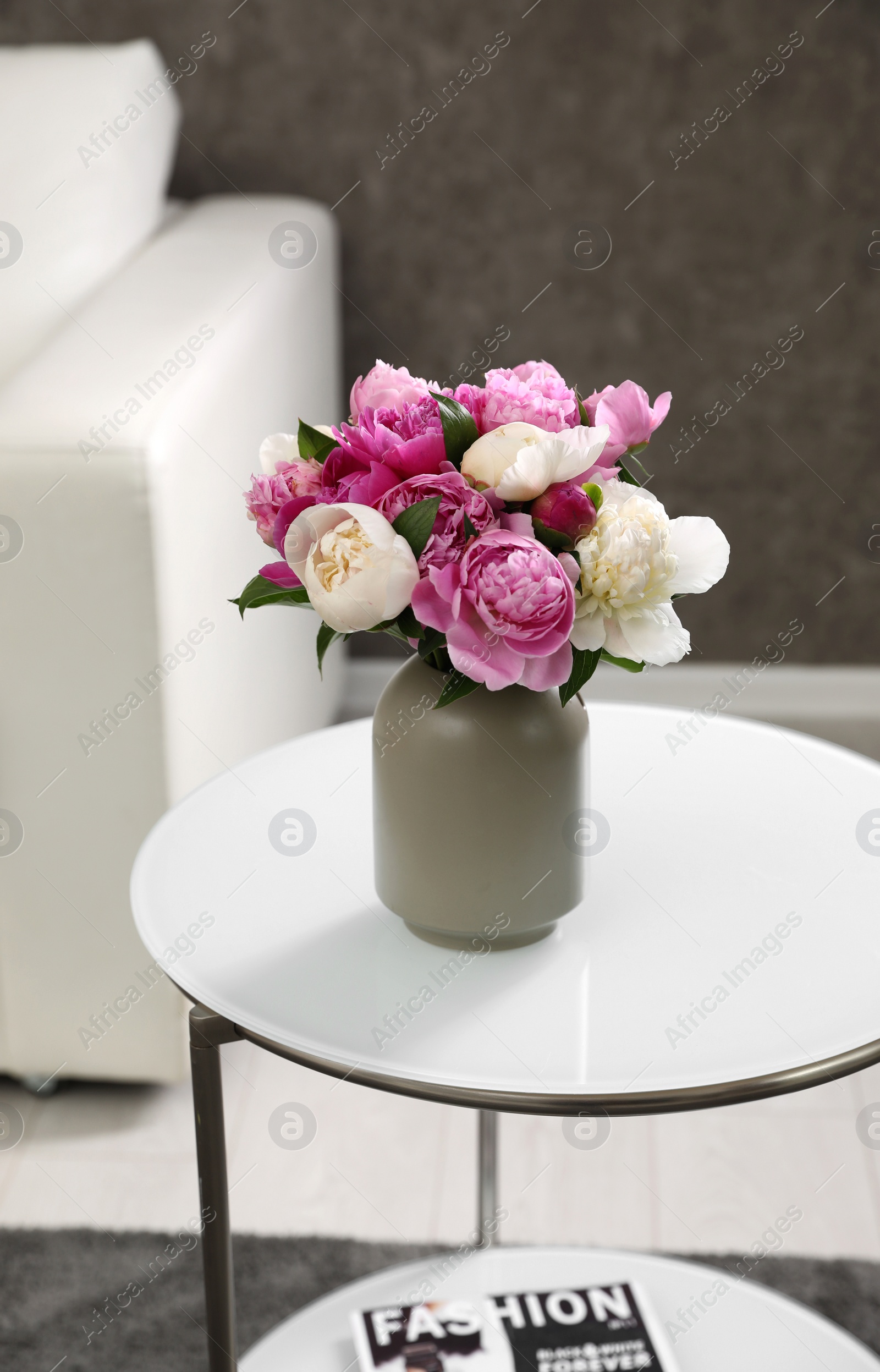 Photo of Vase with bouquet of beautiful peonies on table in room