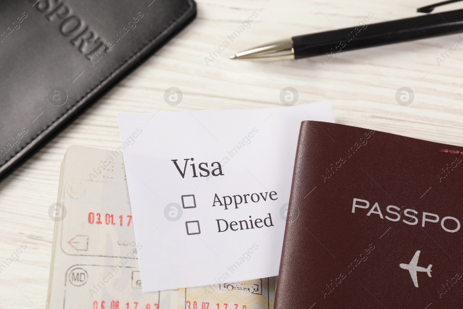 Photo of Moldova, Ceadir-Lunga - June 13, 2022: Passports with visa stamps and pen on white wooden table, closeup