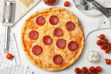 Flat lay composition with tasty pepperoni pizza on white table