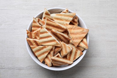 Delicious pita chips on white wooden table, top view