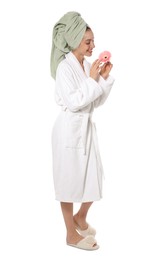 Beautiful young woman with flower wearing bathrobe on white background