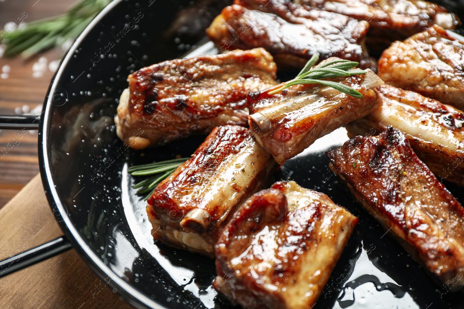 Photo of Delicious grilled ribs with rosemary on table, closeup