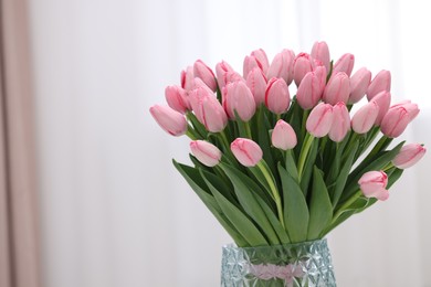 Photo of Bouquet of beautiful pink tulips in vase indoors, space for text