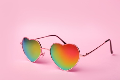 Photo of Modern heart shaped glasses on color background