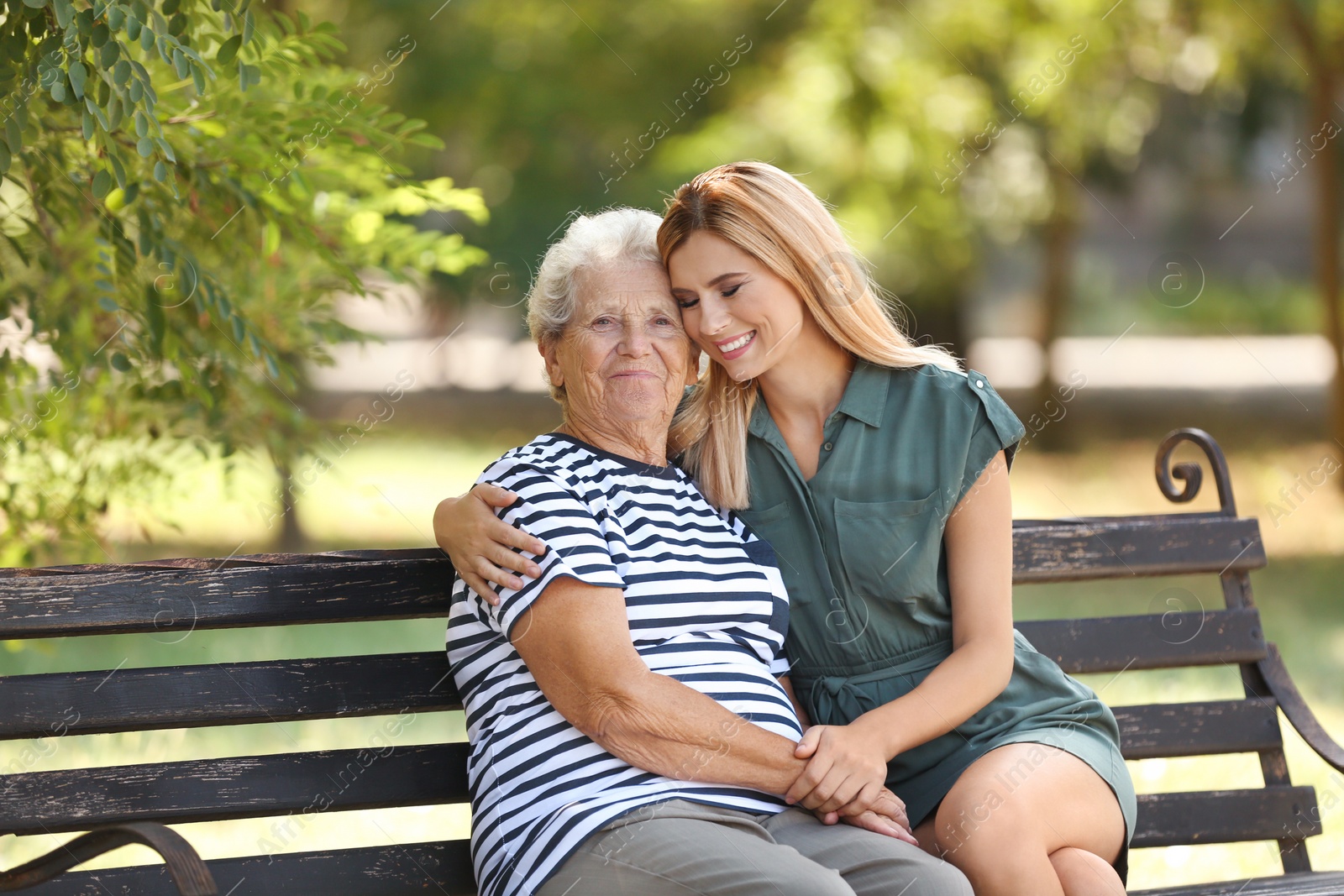 Photo of Woman with elderly mother on bench in park