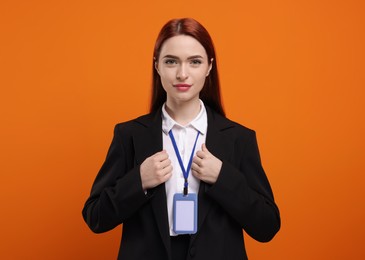 Young woman with vip pass badge on orange background