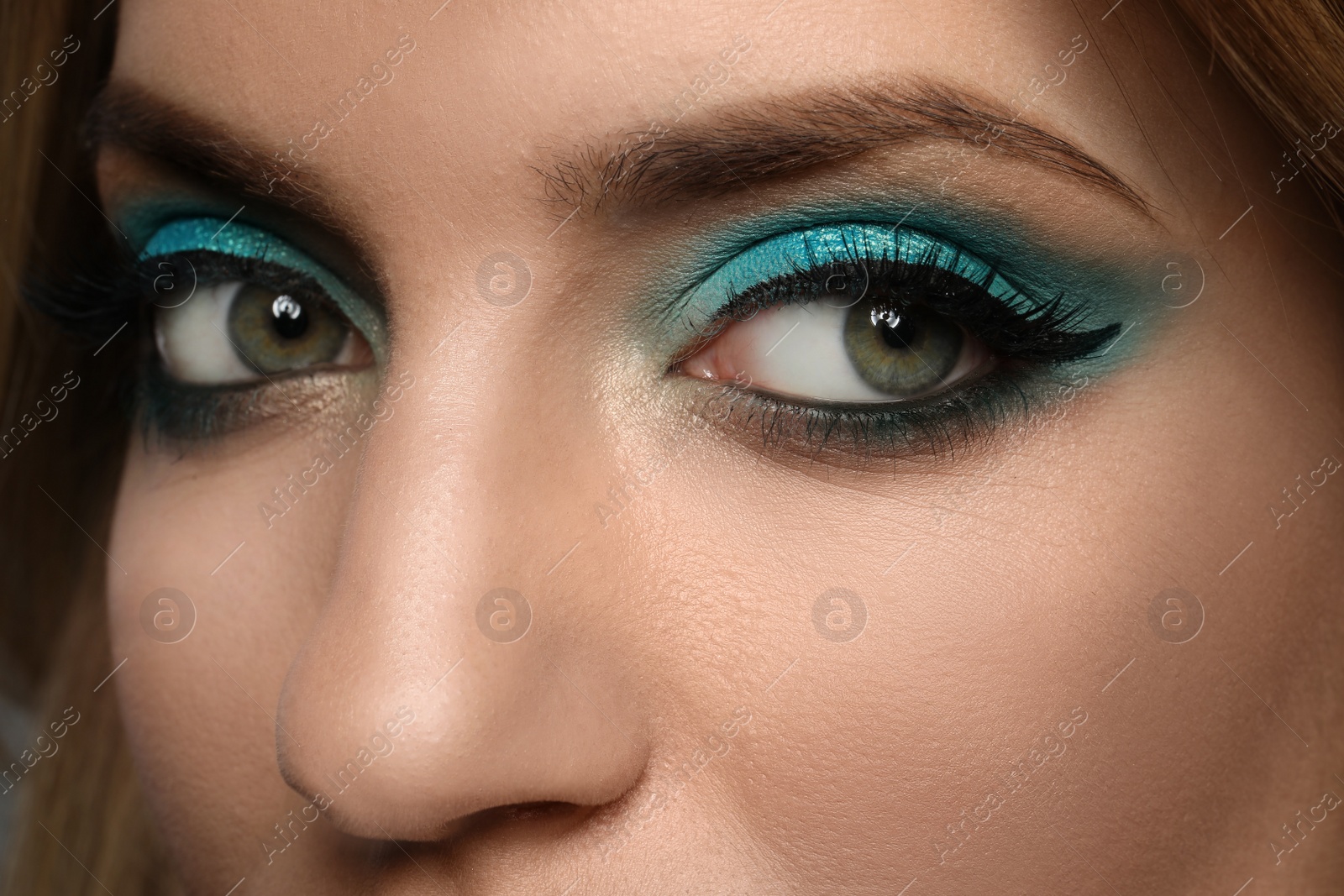 Photo of Young woman with evening makeup, closeup. Eye shadow product