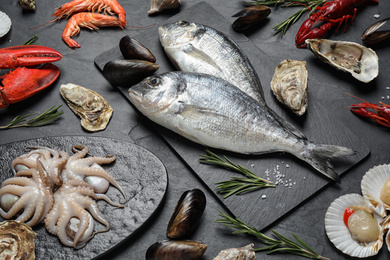 Photo of Fresh fish and different seafood on black table