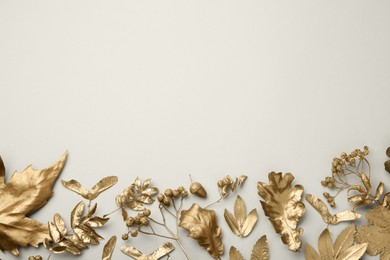 Beautiful golden leaves, berries and acorn on beige background, flat lay with space for text. Autumn decor