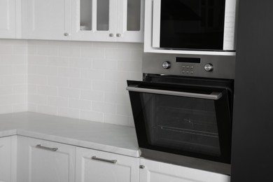 Modern oven and microwave in white clean kitchen