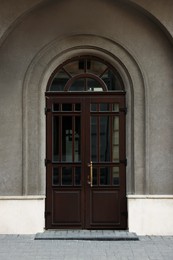 Photo of Entrance of house with beautiful arched wooden door and transom window