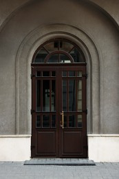 Entrance of house with beautiful arched wooden door and transom window