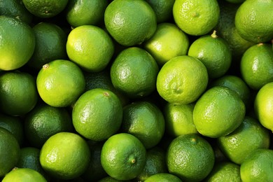 Photo of Fresh ripe green limes as background, top view