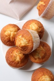 Delicious sweet muffins on white table, flat lay