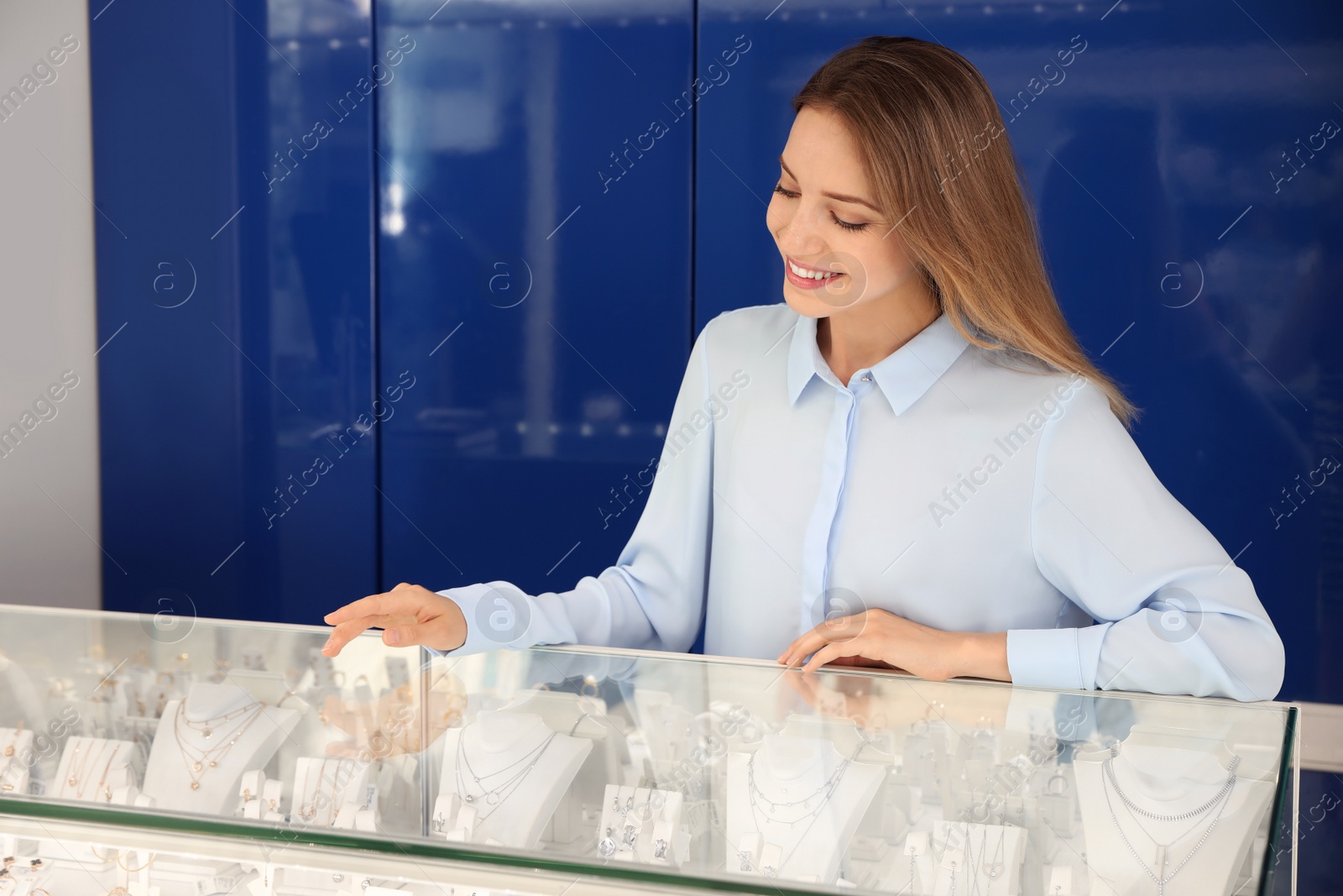 Photo of Portrait of young saleswoman near showcase in jewelry store