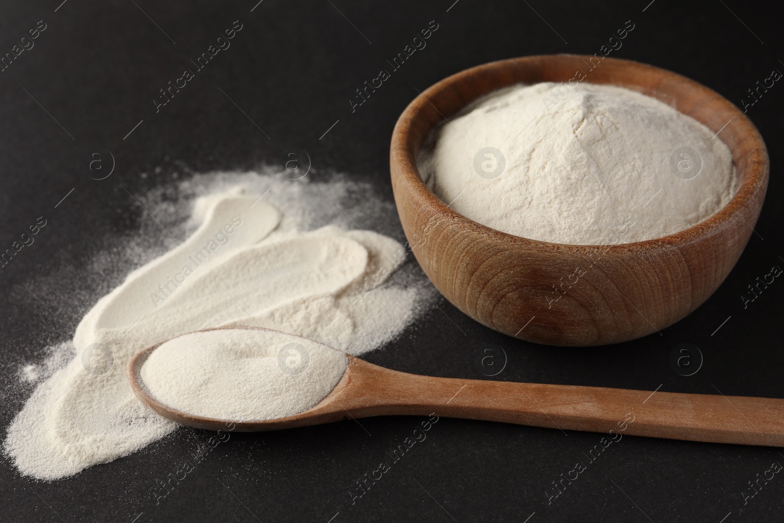 Photo of Spoon and bowl of agar-agar powder on black background