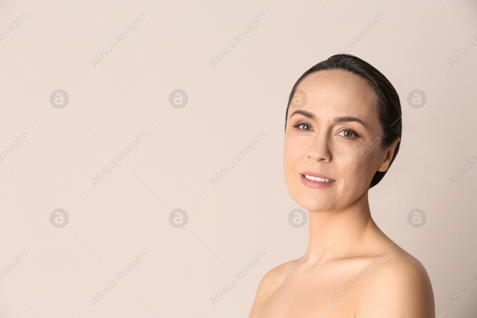 Photo of Portrait of beautiful mature woman on beige background. Space for text