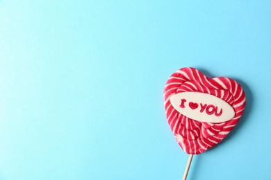 Heart shaped lollipop with phrase I Love You and space for text on color background, top view. Valentine's day celebration