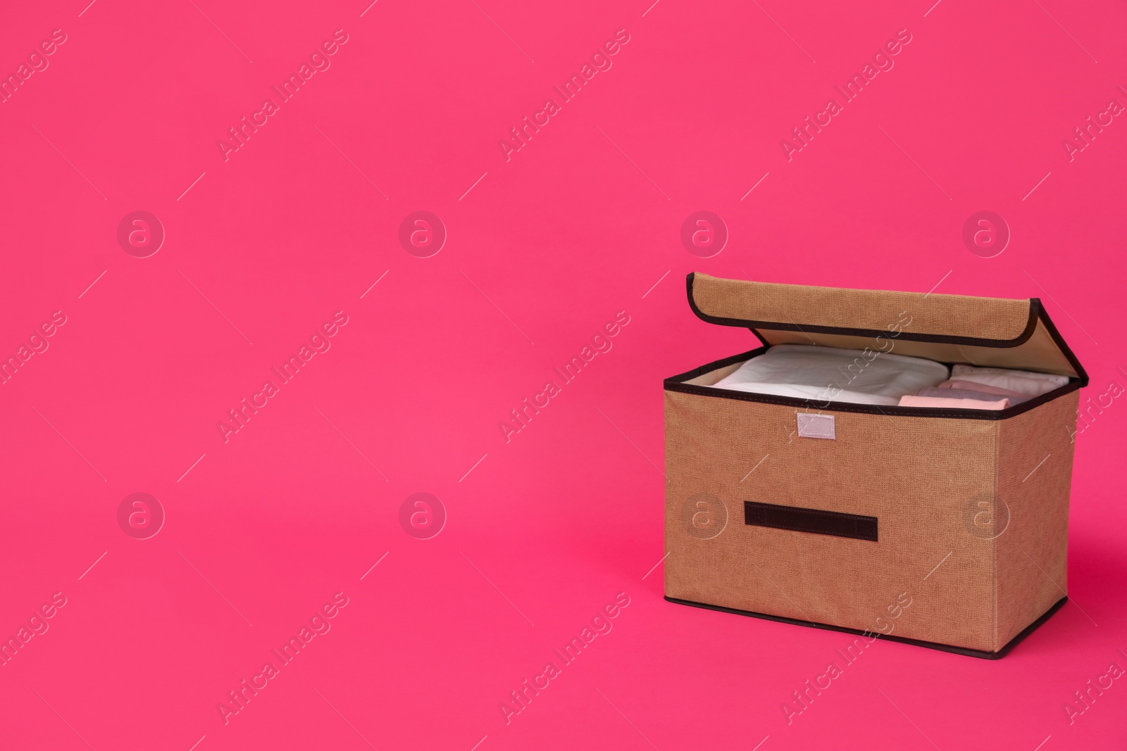 Photo of Textile storage case on pink background. Space for text