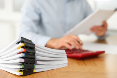 Photo of Man working at wooden table in office, focus on documents. Space for text