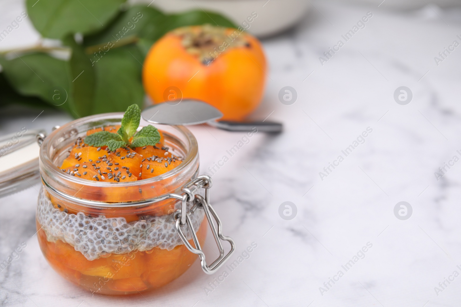 Photo of Delicious dessert with persimmon and chia seeds on table. Space for text