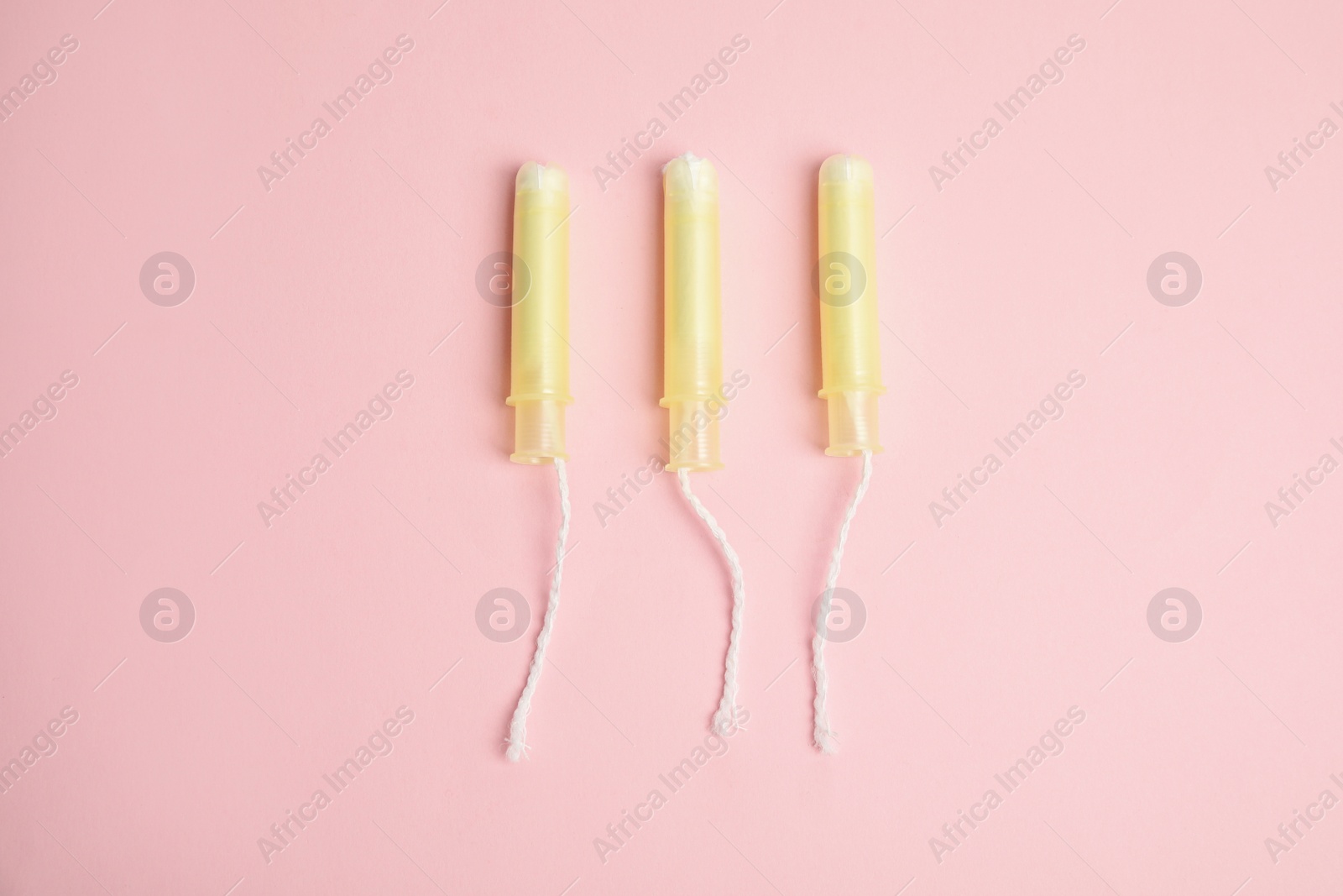 Photo of Tampons on light pink background, flat lay