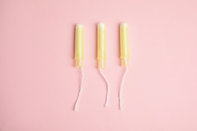 Photo of Tampons on light pink background, flat lay