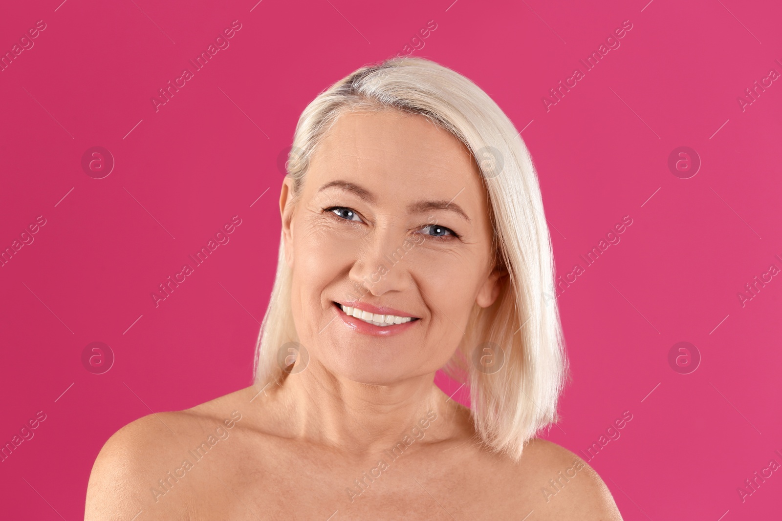 Photo of Portrait of beautiful mature woman on pink background