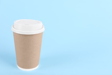 Paper cup with plastic lid on light blue background, space for text. Coffee to go