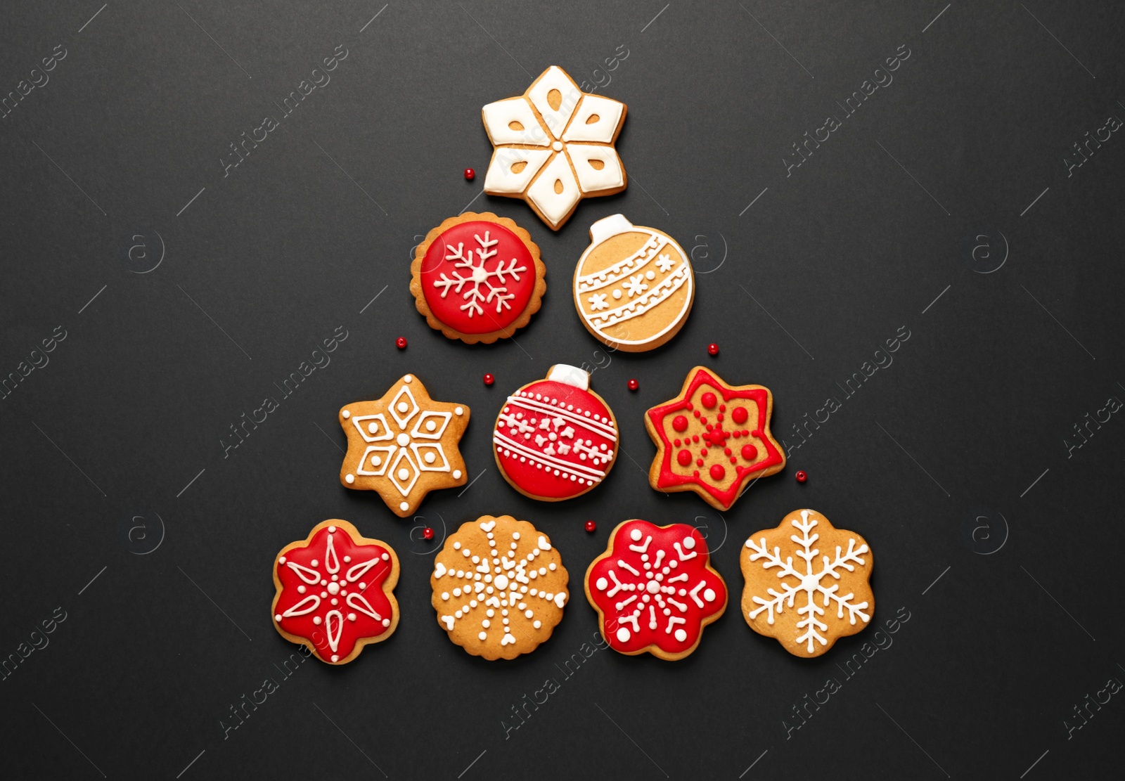 Photo of Christmas tree shape made of tasty homemade cookies on black background, flat lay