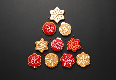 Photo of Christmas tree shape made of tasty homemade cookies on black background, flat lay